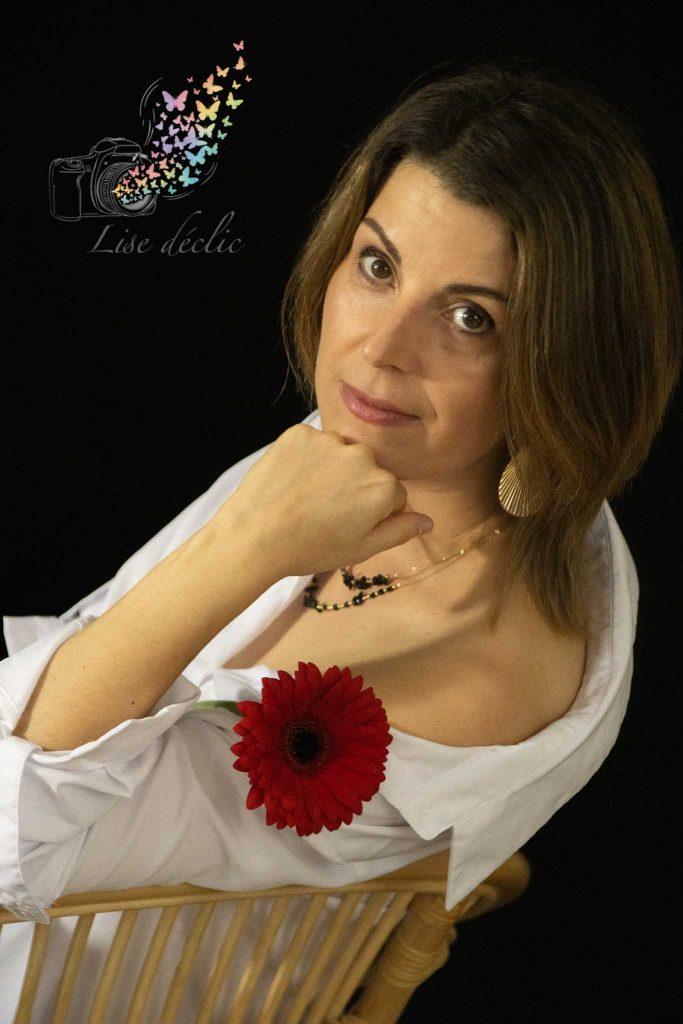 Portrait en studio d’une femme sur fond noir avec fleur rouge – séance photo confiance en soi Lise Déclic
