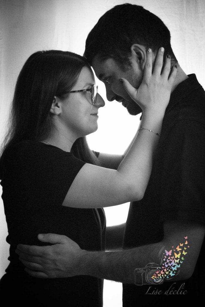 Couple se tenant dans les bras front contre front en portrait noir et blanc lors d’une séance photo authentique