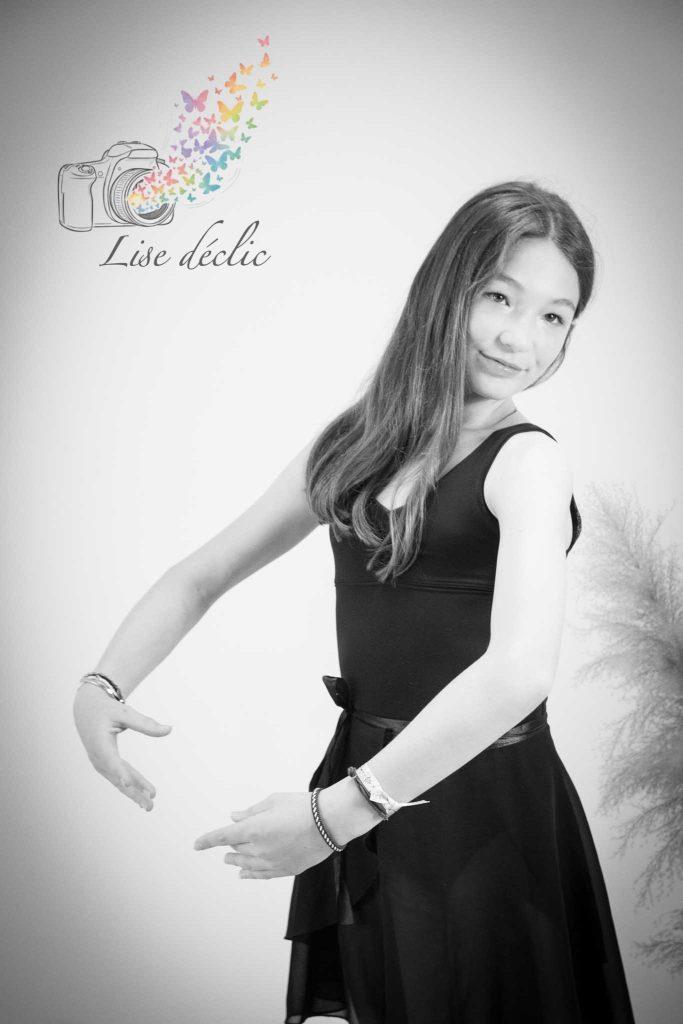 Portrait en noir et blanc d’une jeune fille en tenue de danse adoptant une posture gracieuse lors d’une séance photo authentique
