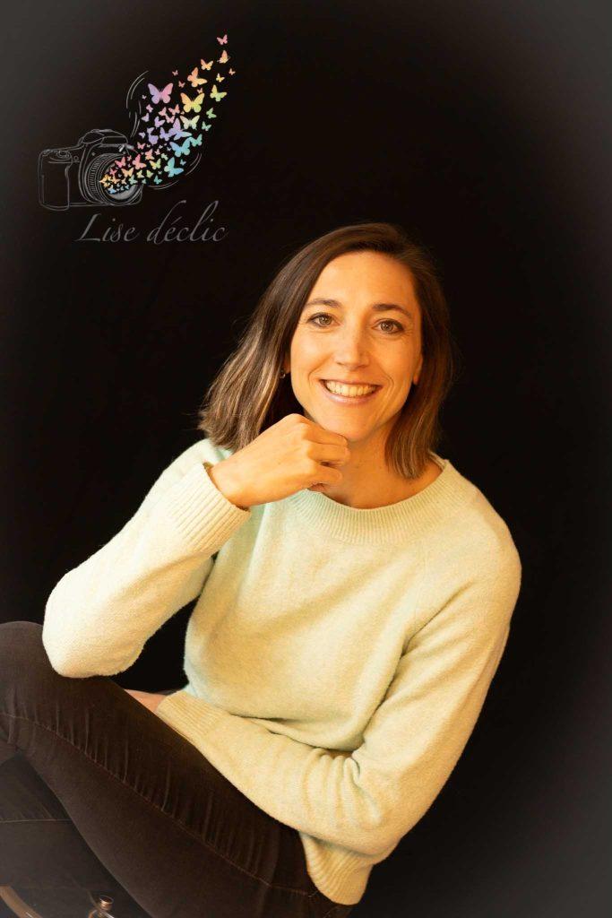 Portrait en studio sur fond noir d’une femme souriante – séance photo confiance en soi Lise Déclic