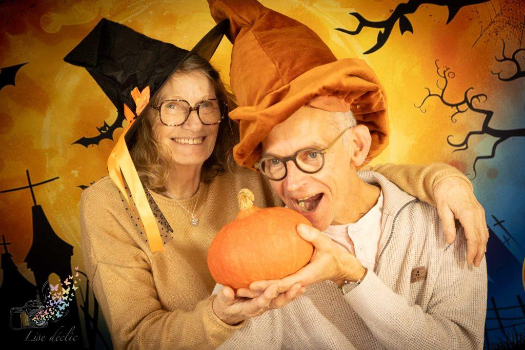 Couple souriant déguisé pour Halloween tenant une citrouille lors d’une mini séance photo à thème