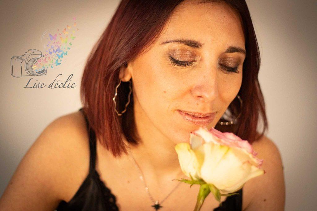 Portrait d’une femme aux cheveux roux respirant une rose, yeux fermés – séance photo S’aimer soi-même Lise Déclic