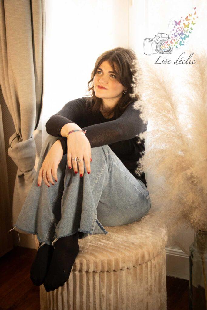Femme assise en intérieur dans une ambiance chaleureuse et naturelle